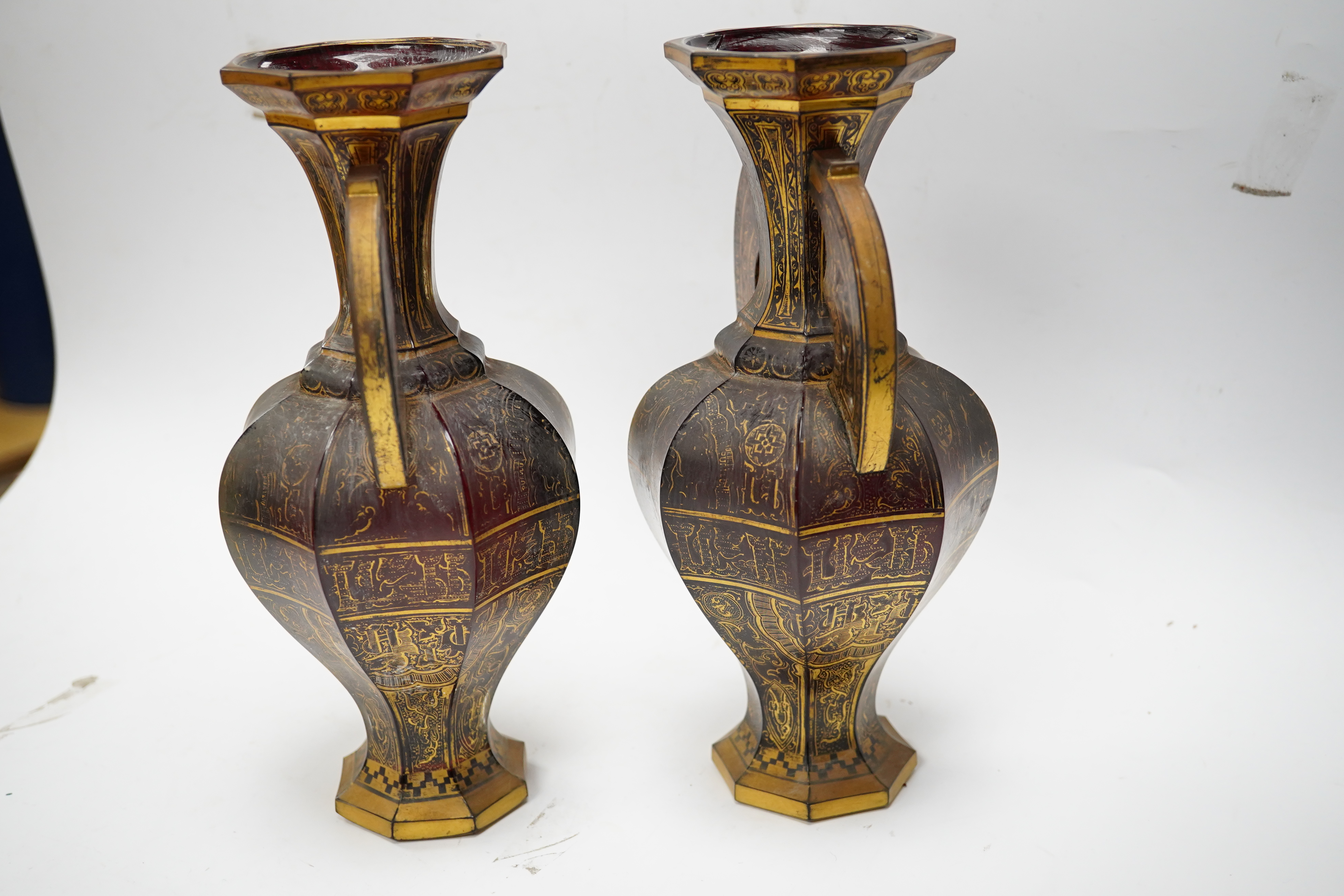 A pair of Venetian Islamic inspired gilt decorated ruby glass twin handled vases, 24cm high. Condition - wear to gilding on both vases